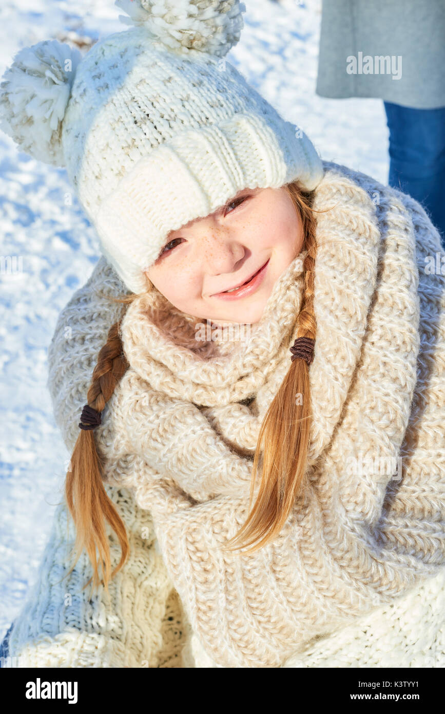 Kleines Mädchen im Winter mit der Lagerung Kappe und Zöpfe Stockfoto