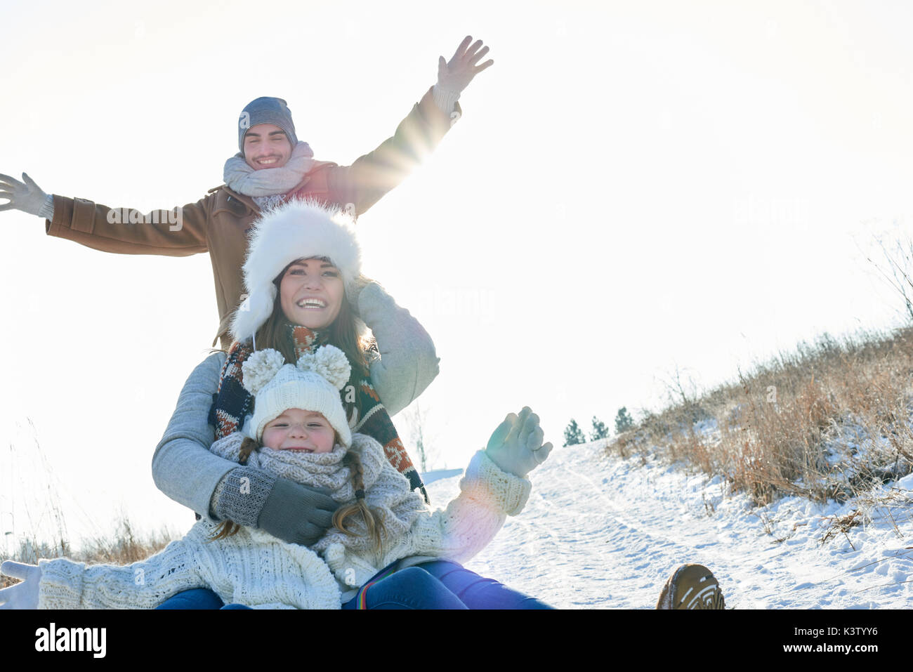 Familie Spaß mit Rodel oder Schlitten im Schnee im Winter Stockfoto