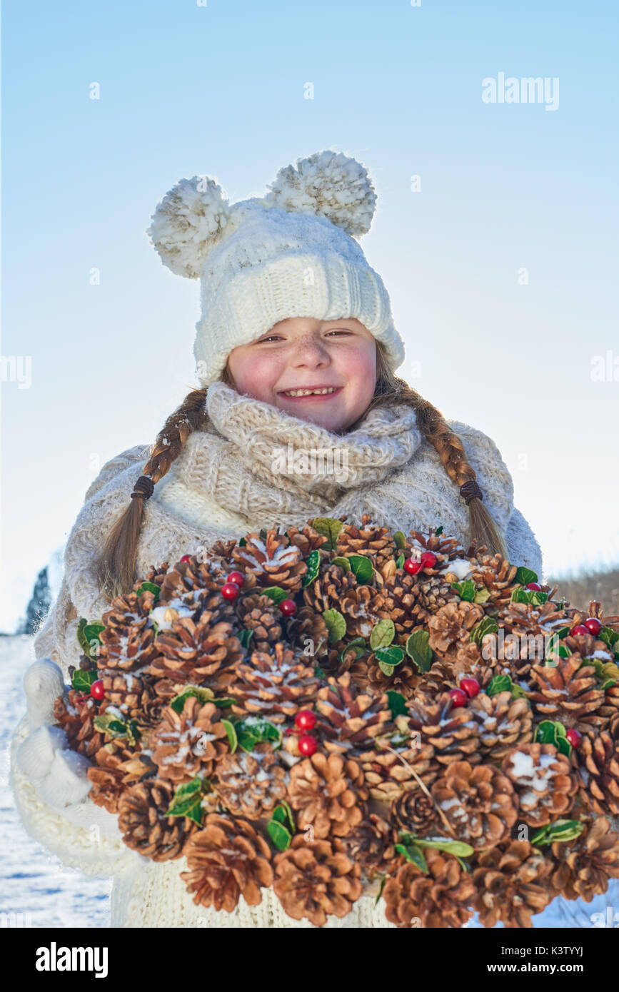 Kind mit Adventskranz, der so glücklich Mädchen in der Weihnachtszeit Stockfoto