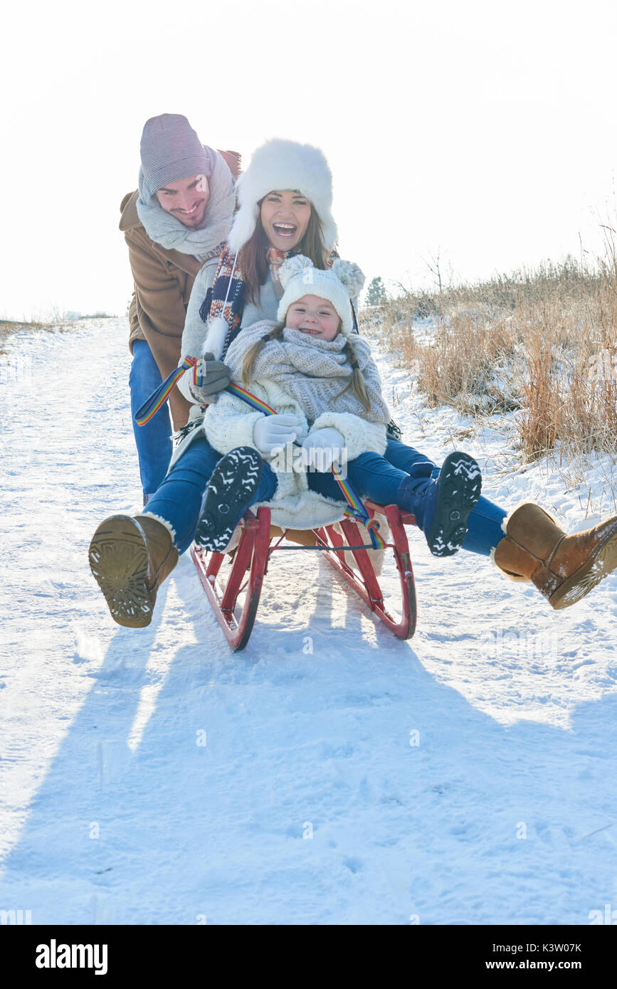 Familie Spaß mit Rodelbahn im Winter im Schnee Stockfoto