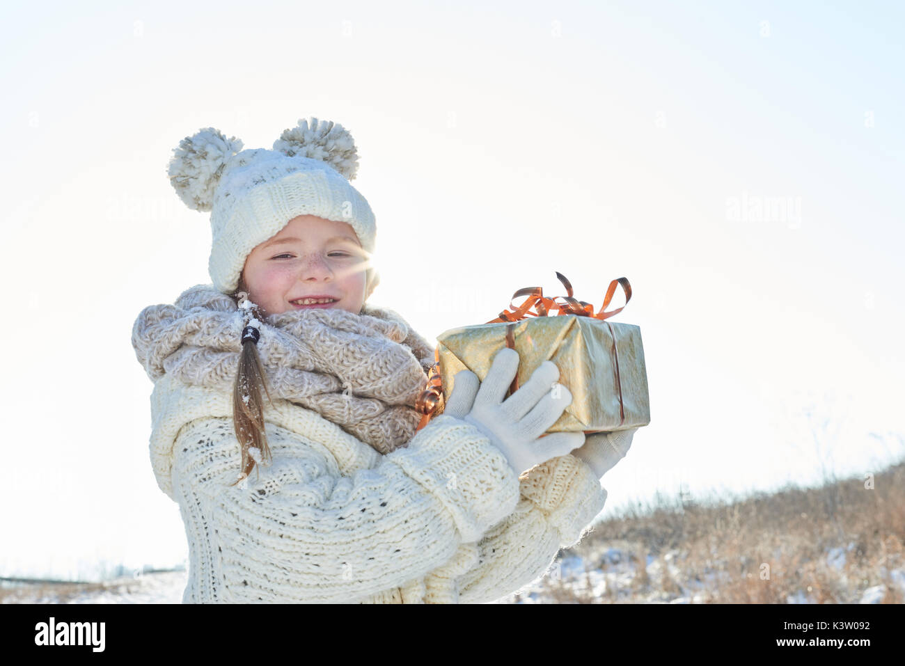 Kind holding Weihnachtsgeschenk mit Freude im Winter Stockfoto