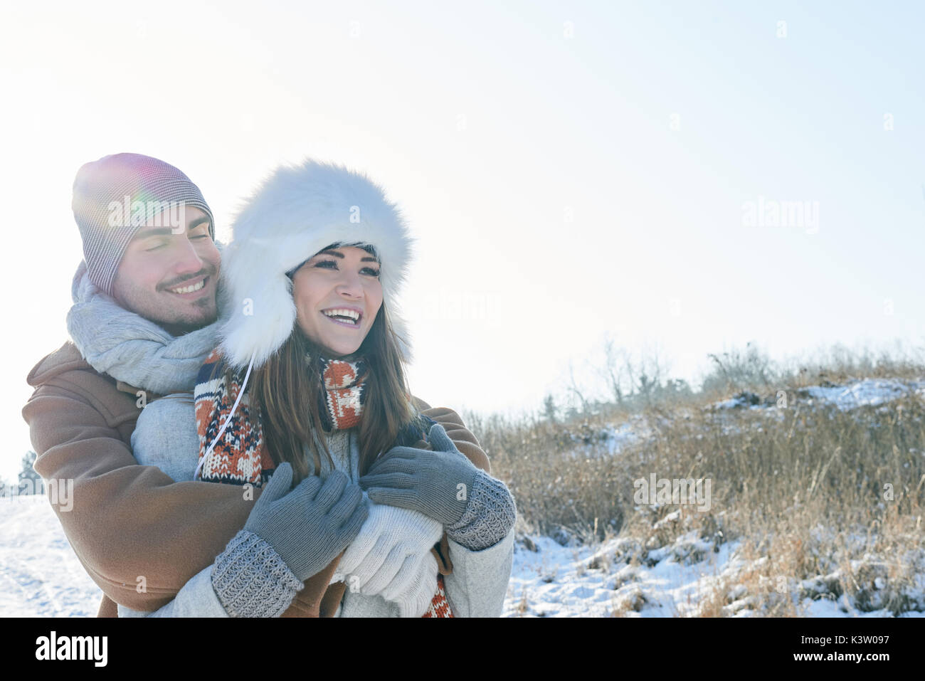 Glückliches Paar in der Liebe das Lachen in den Schnee im Winter Stockfoto