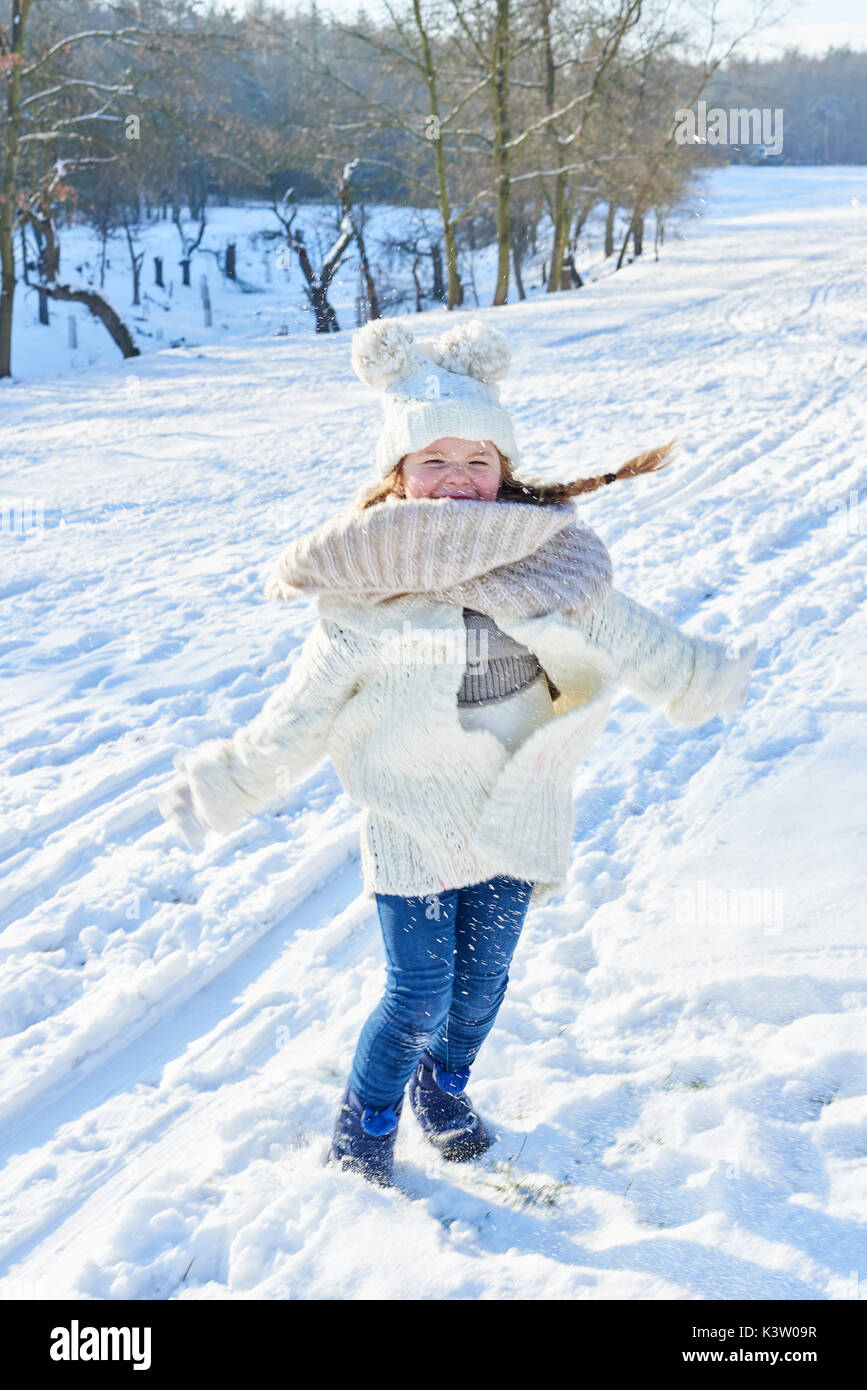 Kleines Mädchen im Winter tanzen und Spaß im Schnee Stockfoto