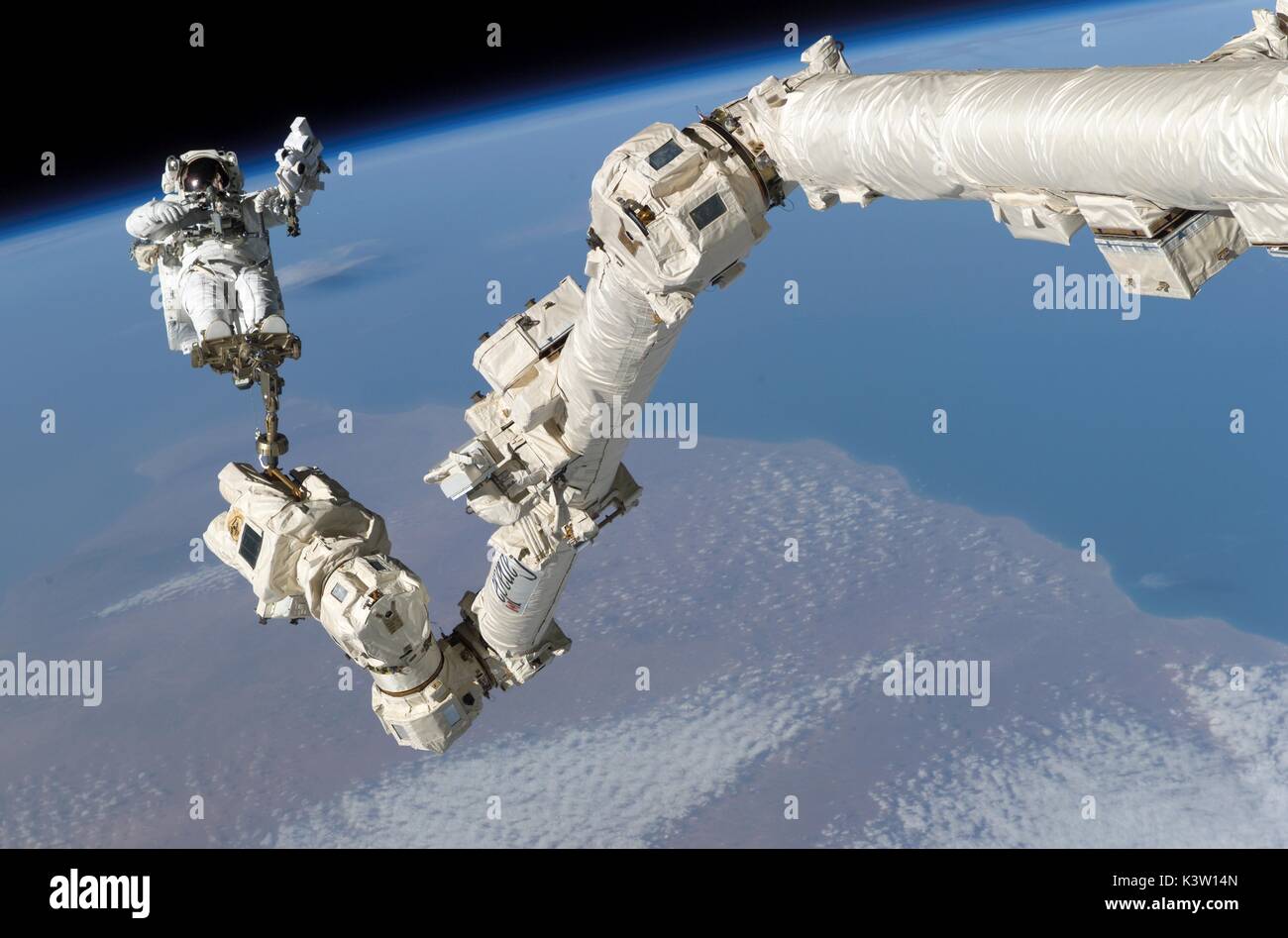 Nasa-Expedition 50 prime Besatzungsmitglied amerikanische Astronaut shane Kimbrough hilft die Internationale Raumstation Roboterarm Canadarm2 befestigen und das unter Druck stehende passender Adapter-3 verlagern (PMA-3), um zu der HARMONY-Modul während einer Eva spacewalk am 26. März 2017 in der Erdumlaufbahn. (Foto: Nasa Foto über planetpix) Stockfoto