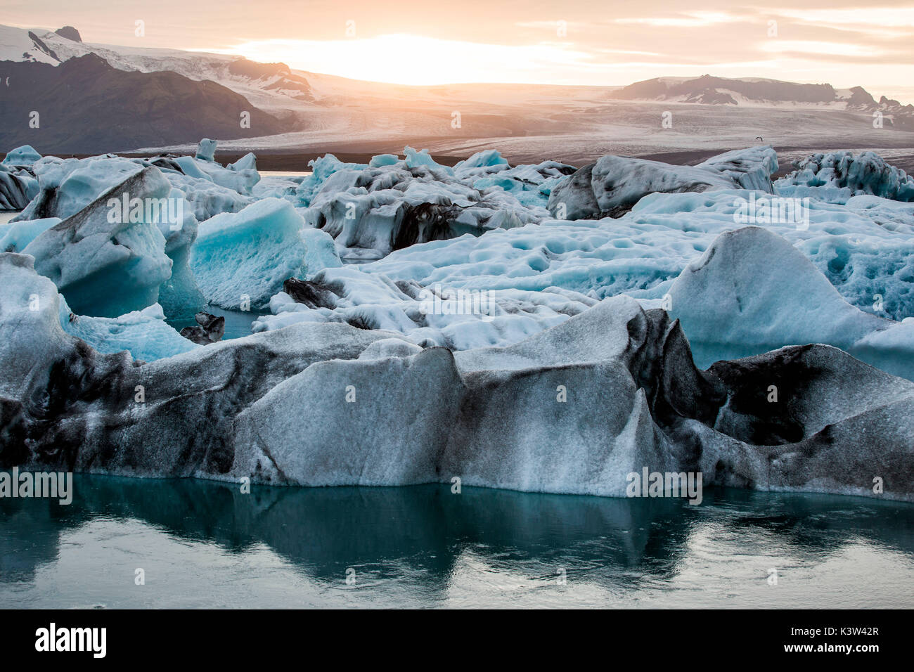 Island, Gletscherlagune Jökulsárlón, Eisberge und Eis Brocken bei Sonnenuntergang Stockfoto