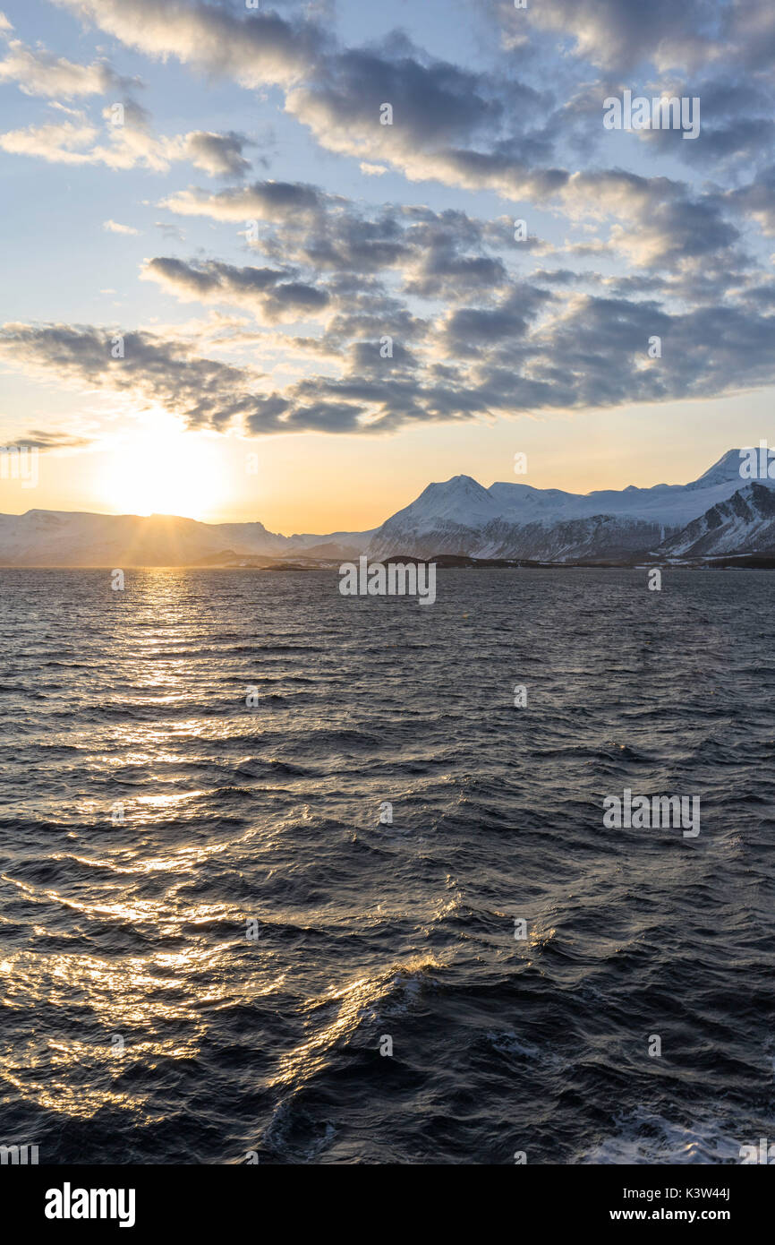 Sun Einstellung während der Fahrt mit der Fähre im Fjord. Lyngenfjord, Lyngen Alpen, Troms, Norwegen, Lappland, Europa. Stockfoto