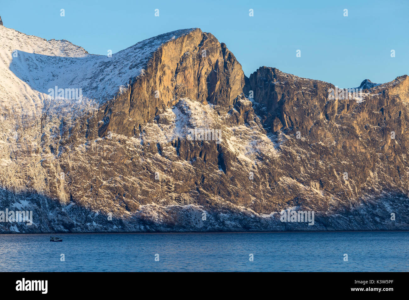 Angeln Boot segelt in Mefjorden mit imposanten Felswände dahinter. Mefjordvaer, Mefjorden, Senja, Norwegen, Europa. Stockfoto