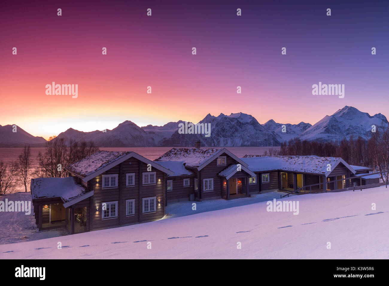 Lyngen Lodge beleuchtet vom Licht des Arktischen Sonnenuntergang. Hammarvika, Lyngenfjord, Lyngen Alpen, Troms, Norwegen, Lappland, Europa. Stockfoto