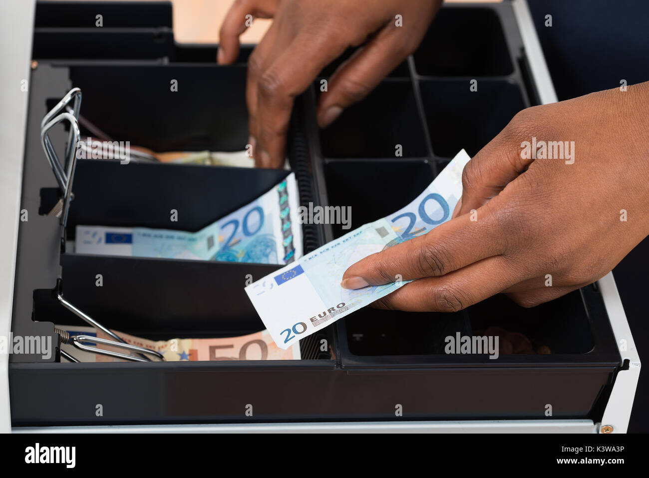 Nahaufnahme einer Hand, die Euro Person Hinweis über Container Stockfoto