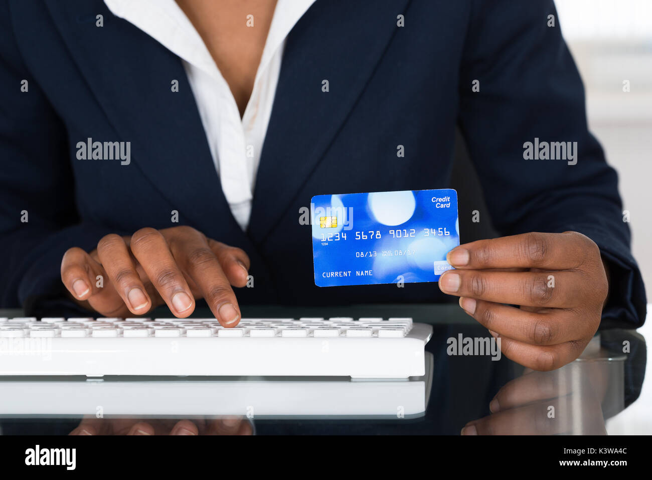 Nahaufnahme der Person's Hand, die Kreditkarte beim Tippen auf der Tastatur Stockfoto