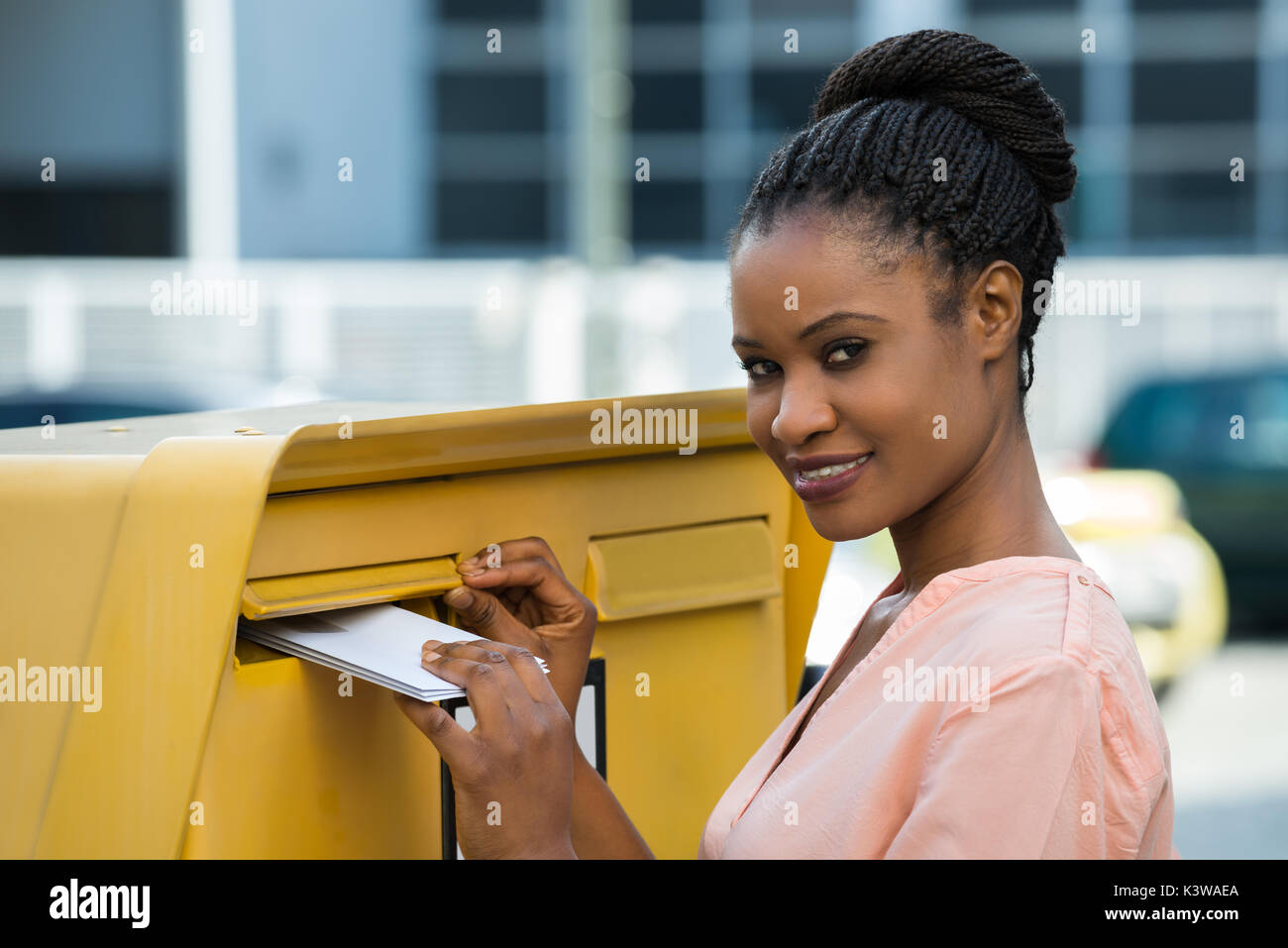 Junge afrikanische Frau einfügen Schreiben in der Mailbox Stockfoto