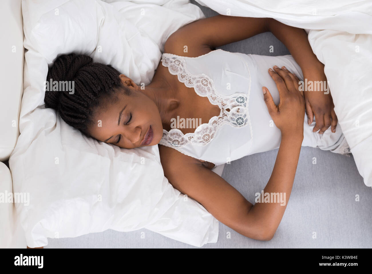 Hohe Betrachtungswinkel der jungen afrikanischen Frau schlafend auf dem Bett Stockfoto