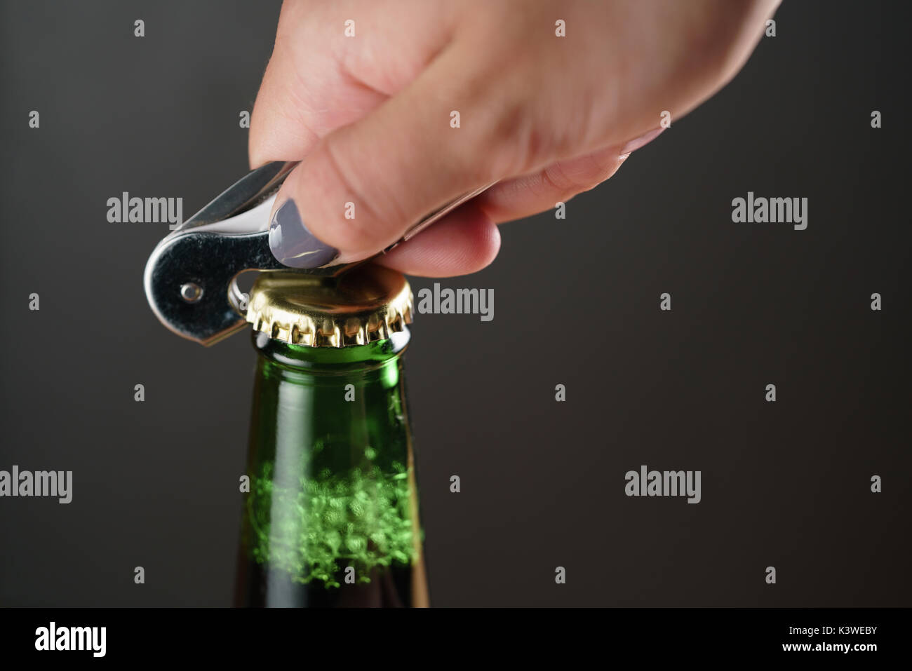 Closeup junge weibliche Hand open green Bier Flasche Stockfoto