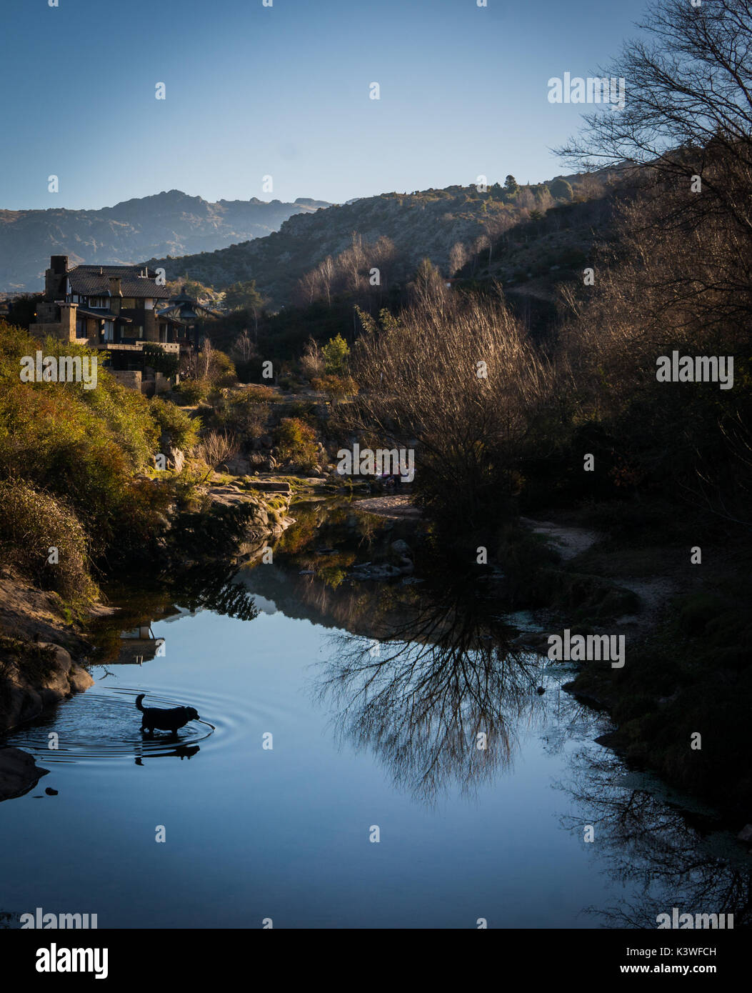 Hund bekommt in den See und die Ruinen meiner Reflexion Foto aber eigentlich mag ich es am besten. Schönes Haus in den Bergen in La Cumbrecita, Cordoba, Argentinien Stockfoto