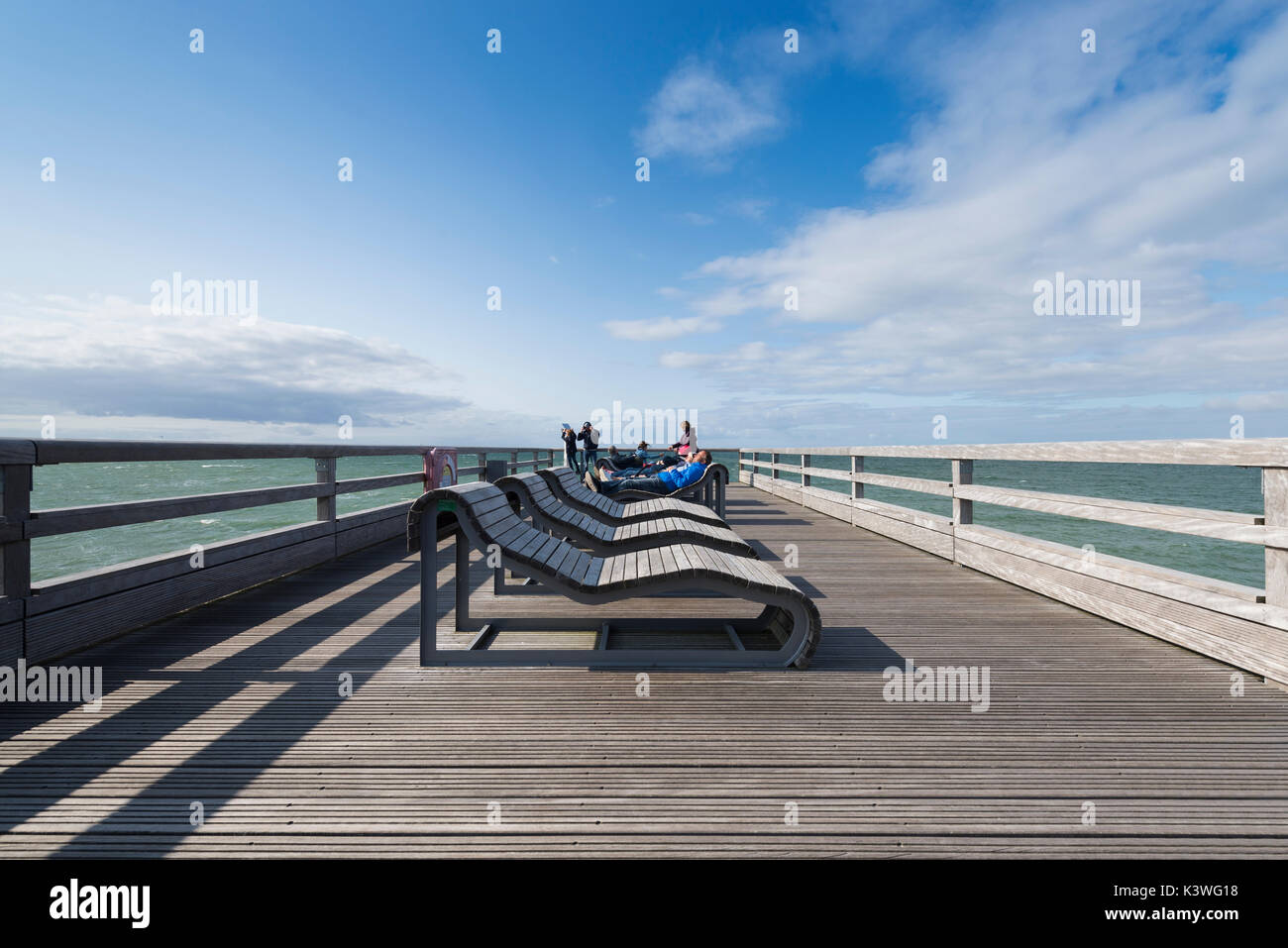 Menschen Sonnenbad auf den Liegestühlen auf dem Pier von heiligenhafen an der Ostsee, Schleswig-Holstein, Deutschland Stockfoto