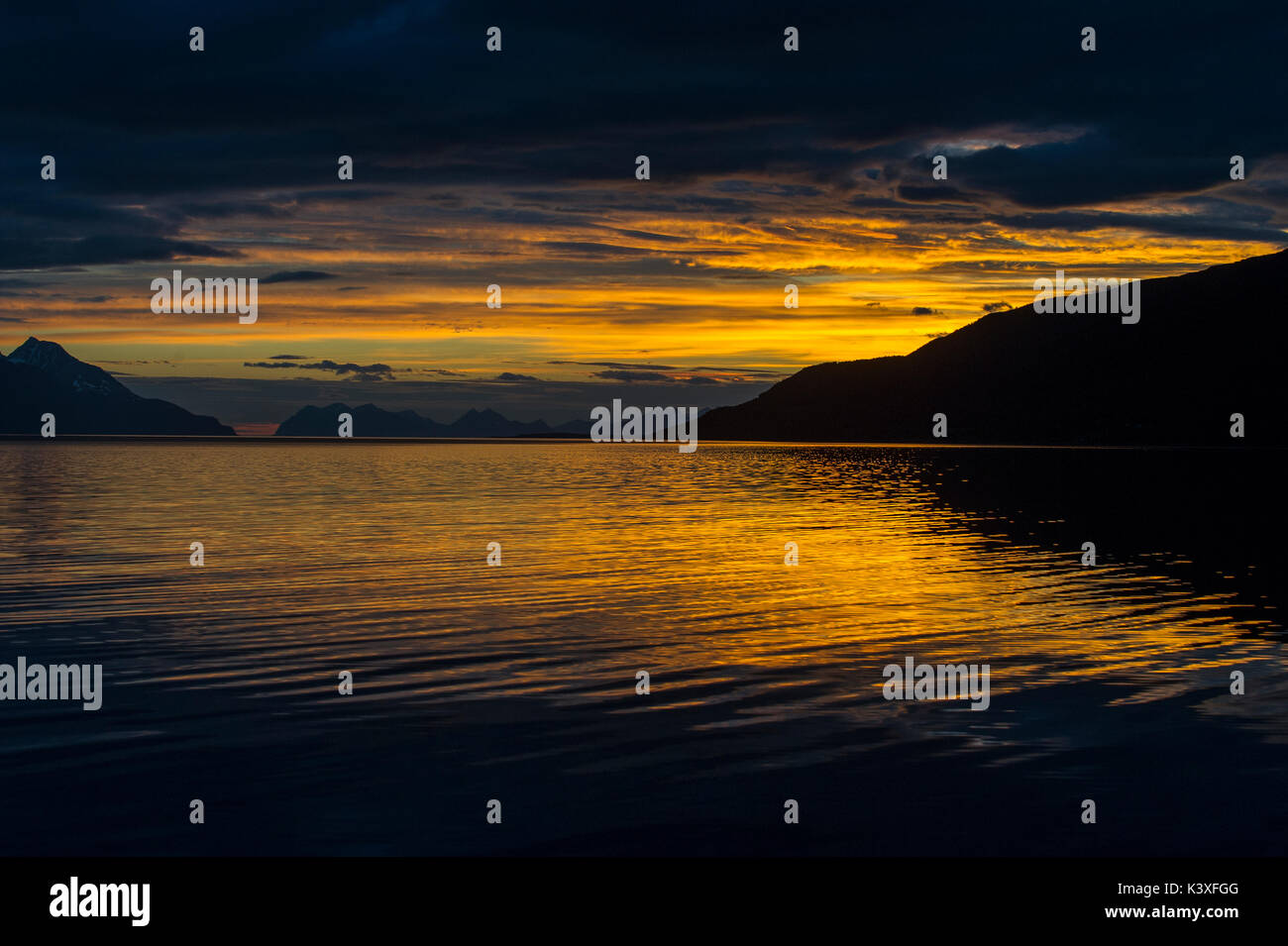 Sunrise spiegelt sich im Meer in Lyngenfjord nördlich des Polarkreises, Norwegen im Sommer. Stockfoto