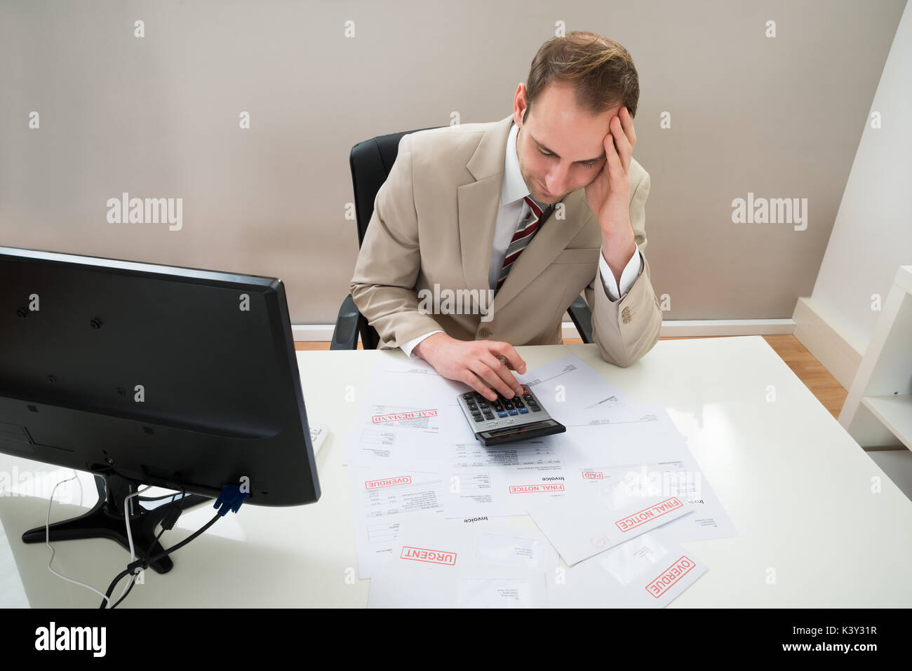 Portrait von besorgt Geschäftsmann Berechnung unbezahlte Rechnungen am Schreibtisch Stockfoto