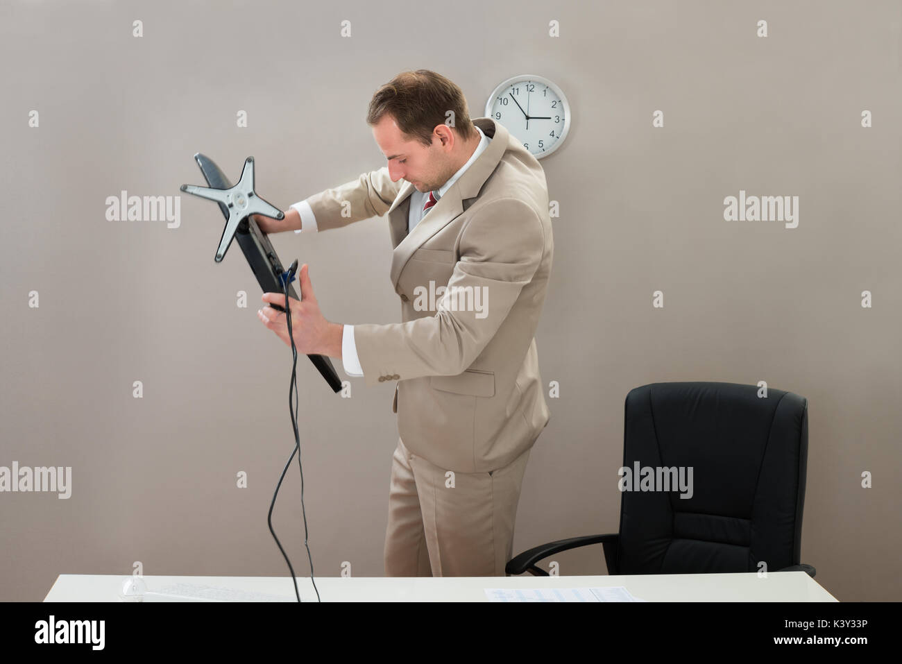 Mitte der Erwachsenen Geschäftsmann Anheben Desktop-Computer im Büro Stockfoto