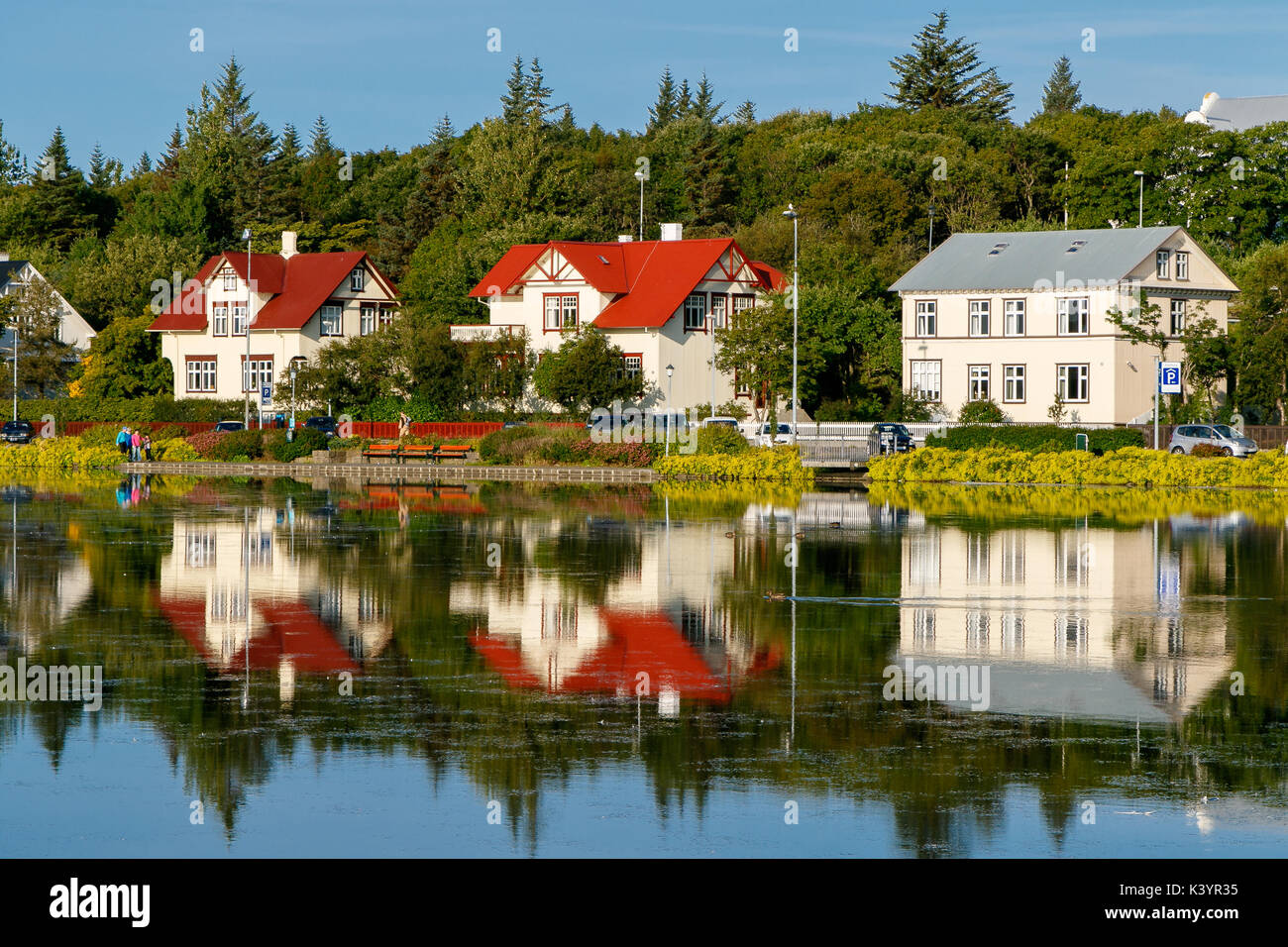 Bunte Häuser durch einen Teich in Reykjavik an einem Sommermorgen. Stockfoto