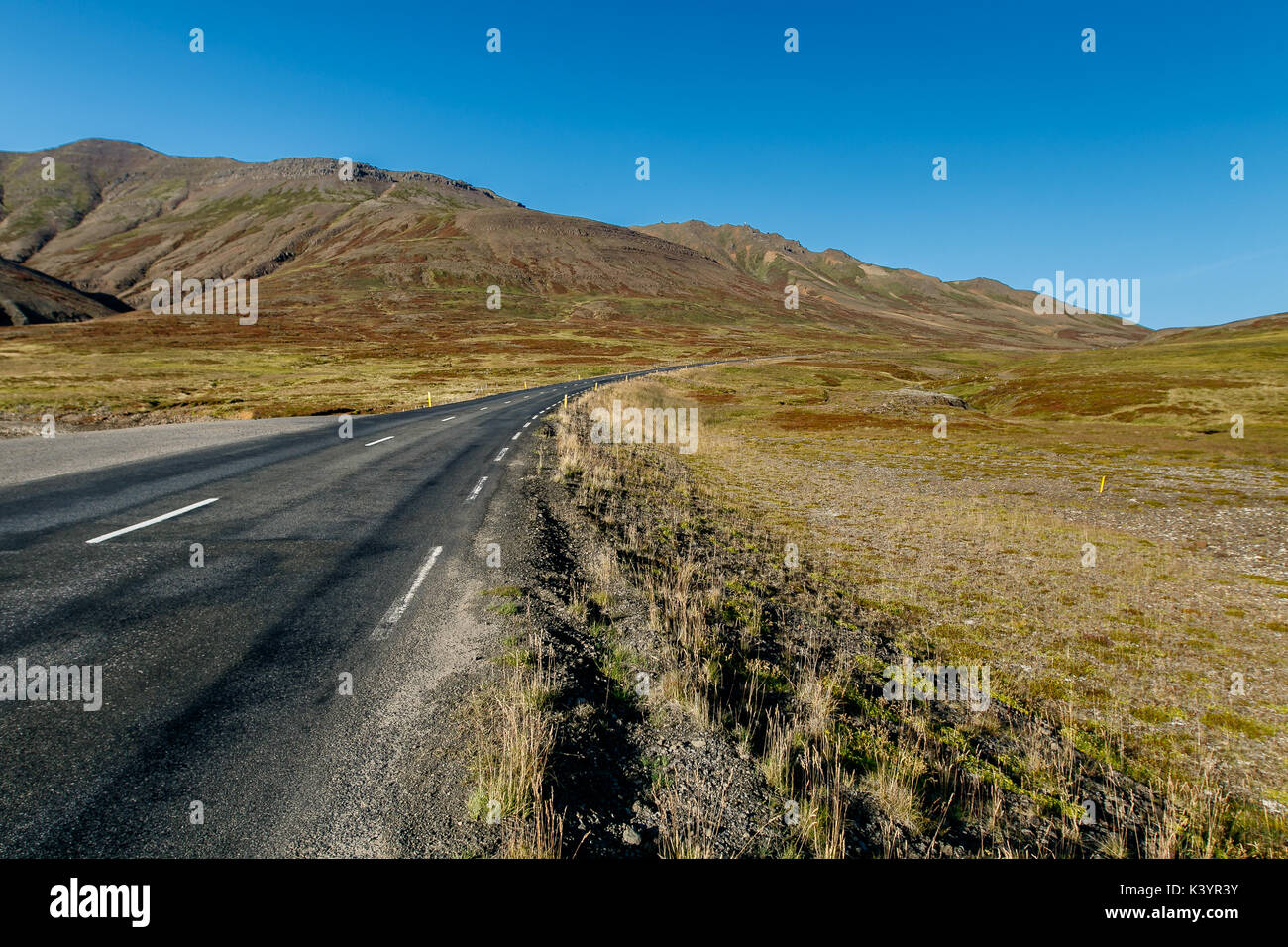 Gepflasterte Straße in Island in Richtung des Unbekannten. Stockfoto