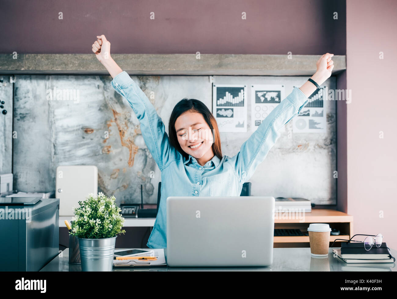 Asiatische kreative Designer Arm anheben und Auge vor Laptop auf dem Schreibtisch, von der harten Arbeit im Büro entspannen. Stockfoto