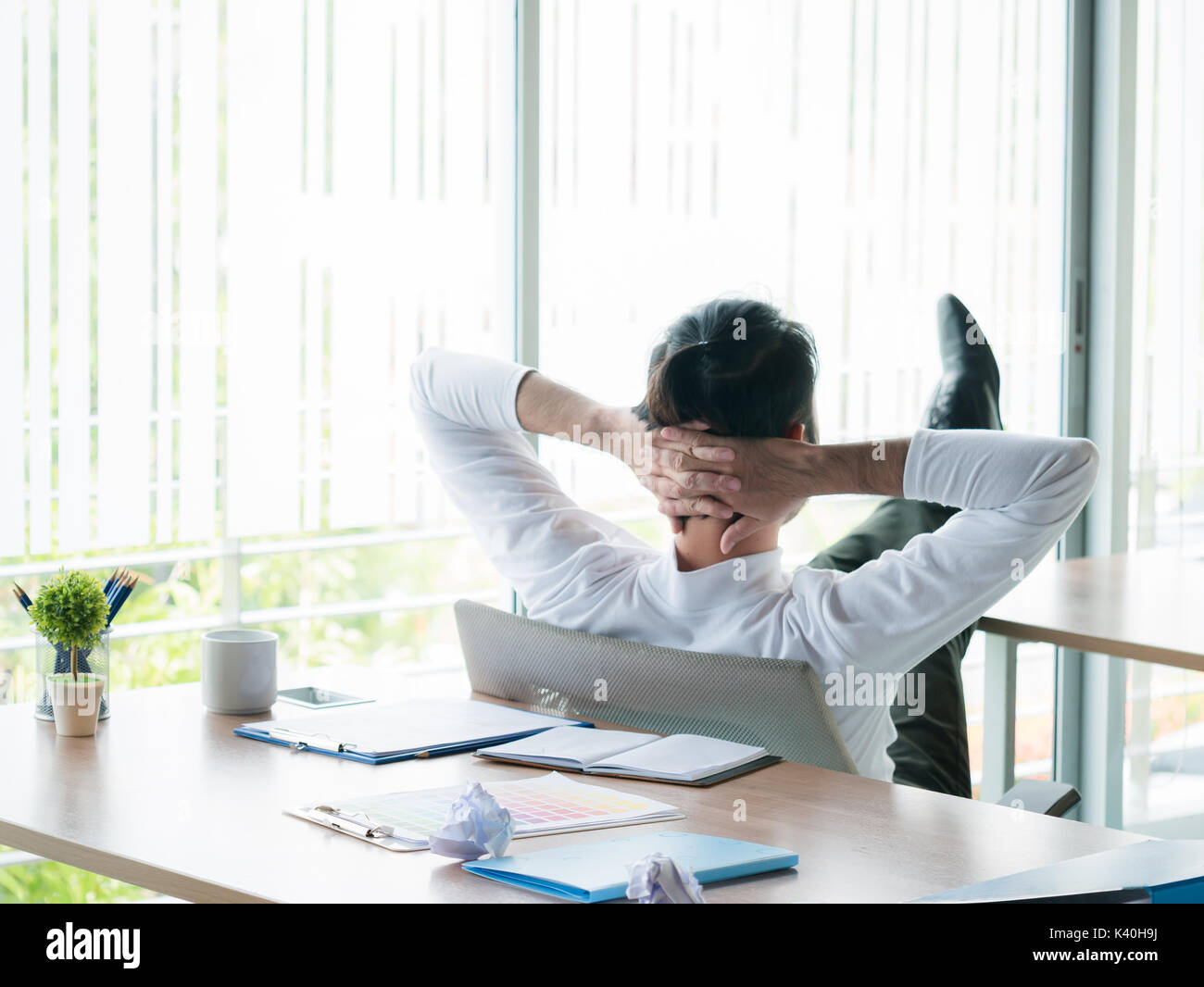 Geschäftsmann entspannende Konzept: Geschäftsmann mit Füßen sitzen im Büro Schreibtisch Blick aus Fenster in der Zeit rest Stockfoto