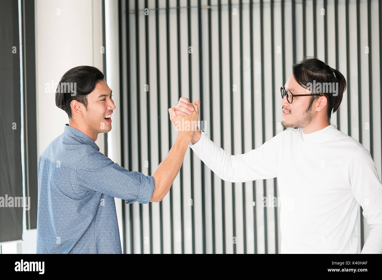 Portrait eines glücklichen jungen Mann im Amt klatschen ihre Hände ok Geste asiatischer smart aussehenden Leute Stockfoto