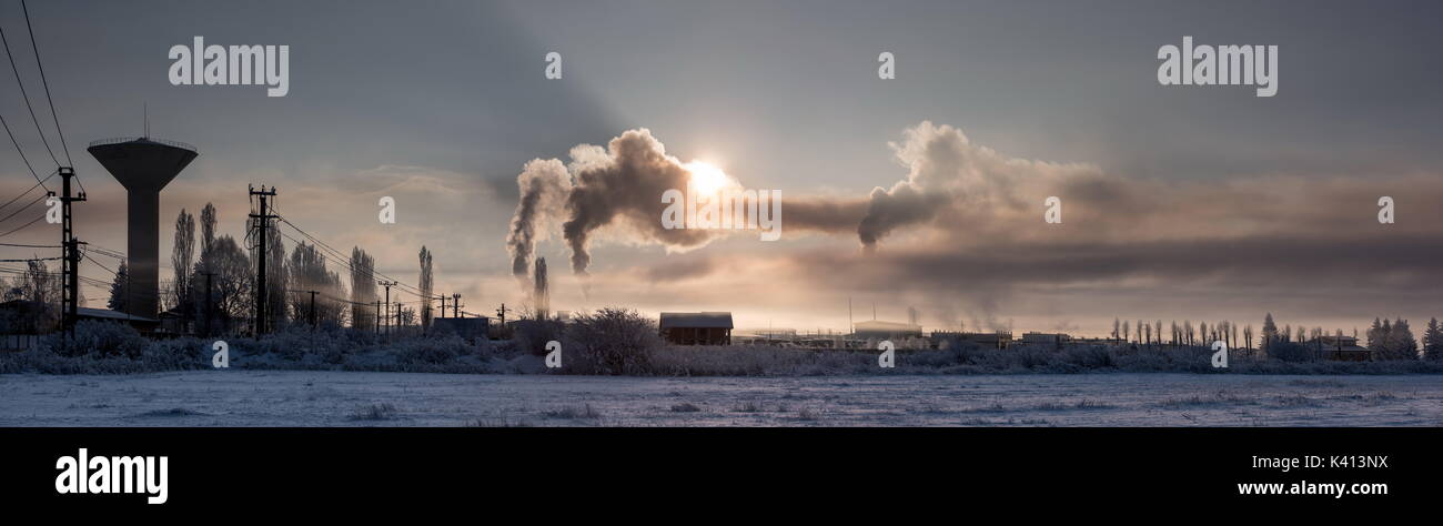 Es ist sehr kalt in den Sonnenaufgang industrielle Landschaft. Schadstoffe in die Atmosphäre. Stockfoto