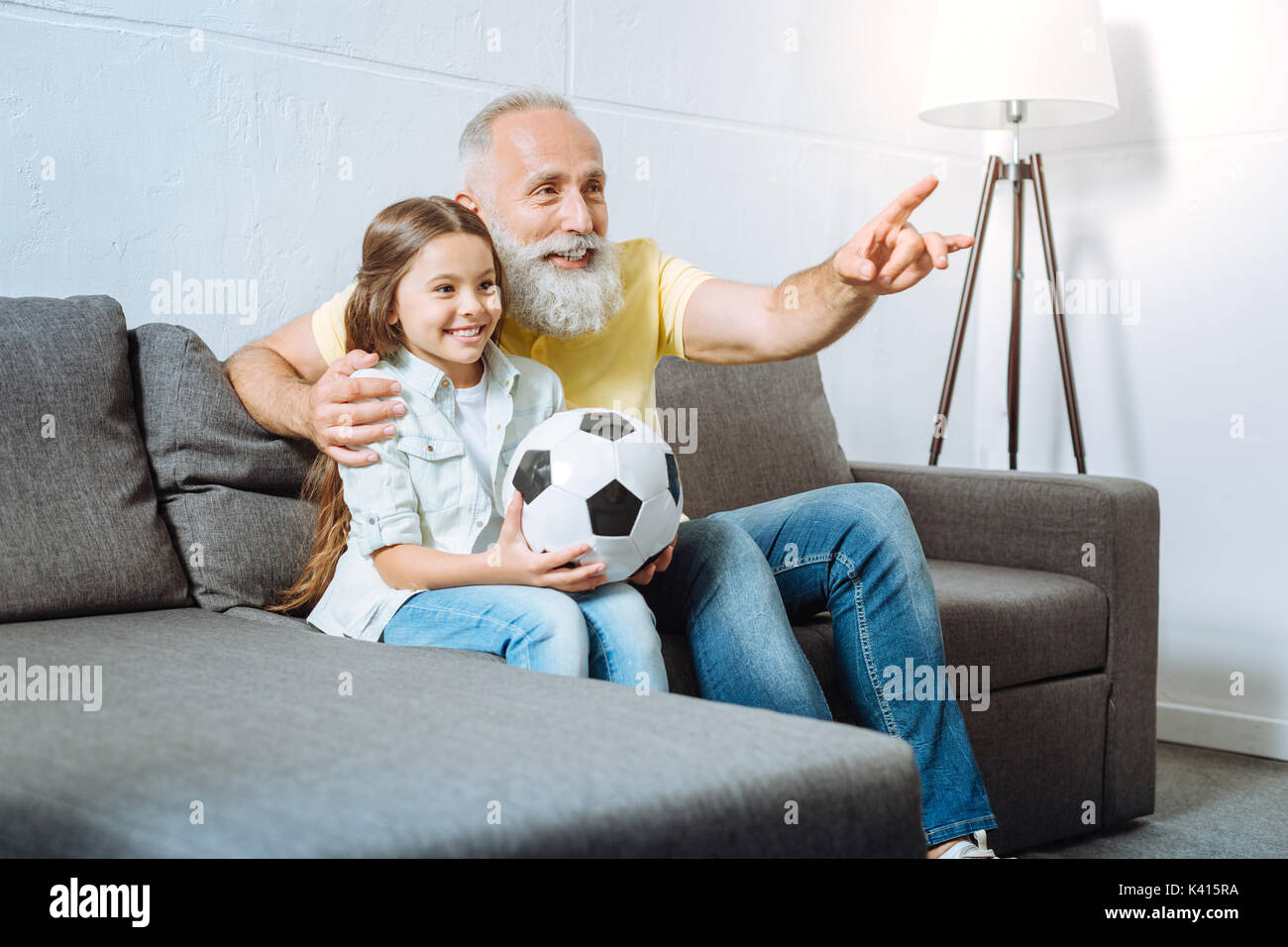 Großvater und seine Enkelin gemeinsam Fußballgucken Stockfoto