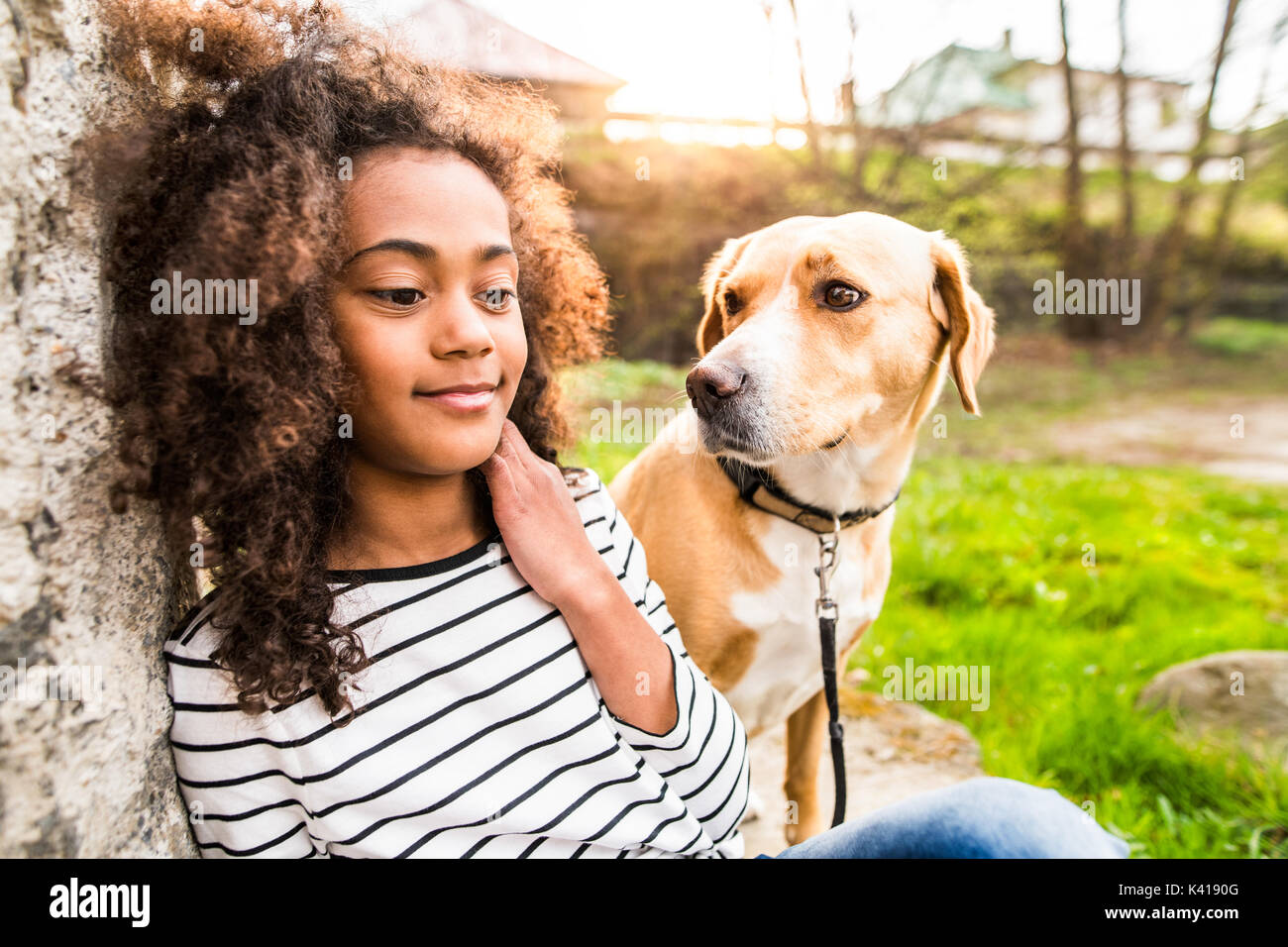 Afrikanische amerikanische Mädchen mit ihrem Hund an der Betonwand. Stockfoto