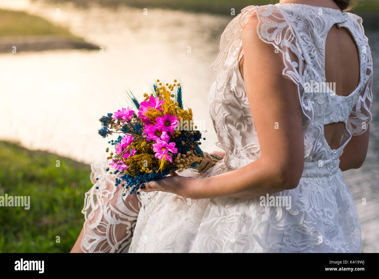 Braut Hochzeit halten, bunten Blumenstrauß am See Stockfoto