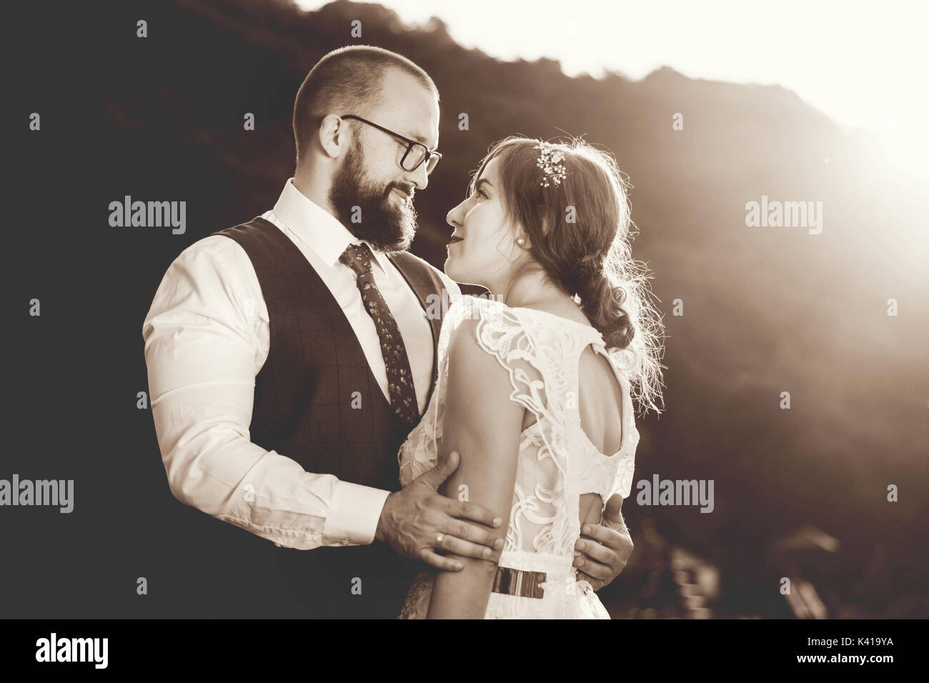Braut und Bräutigam umarmen passionatelly bei Sonnenuntergang, schwarz und weiß Stockfoto