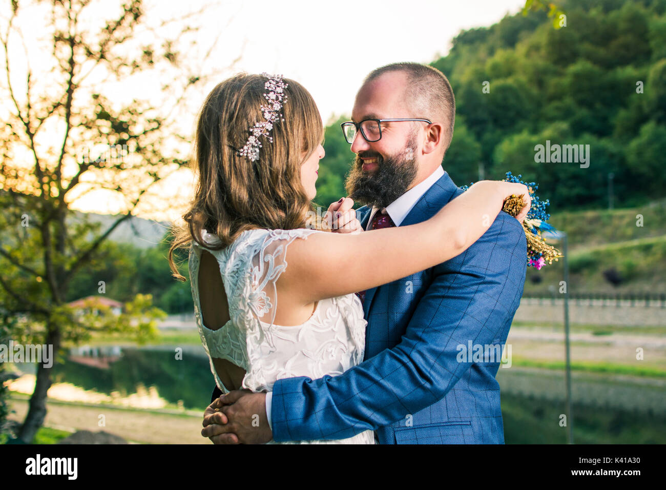 Braut und Bräutigam umarmen passionatelly an romantischen Sonnenuntergang Stockfoto
