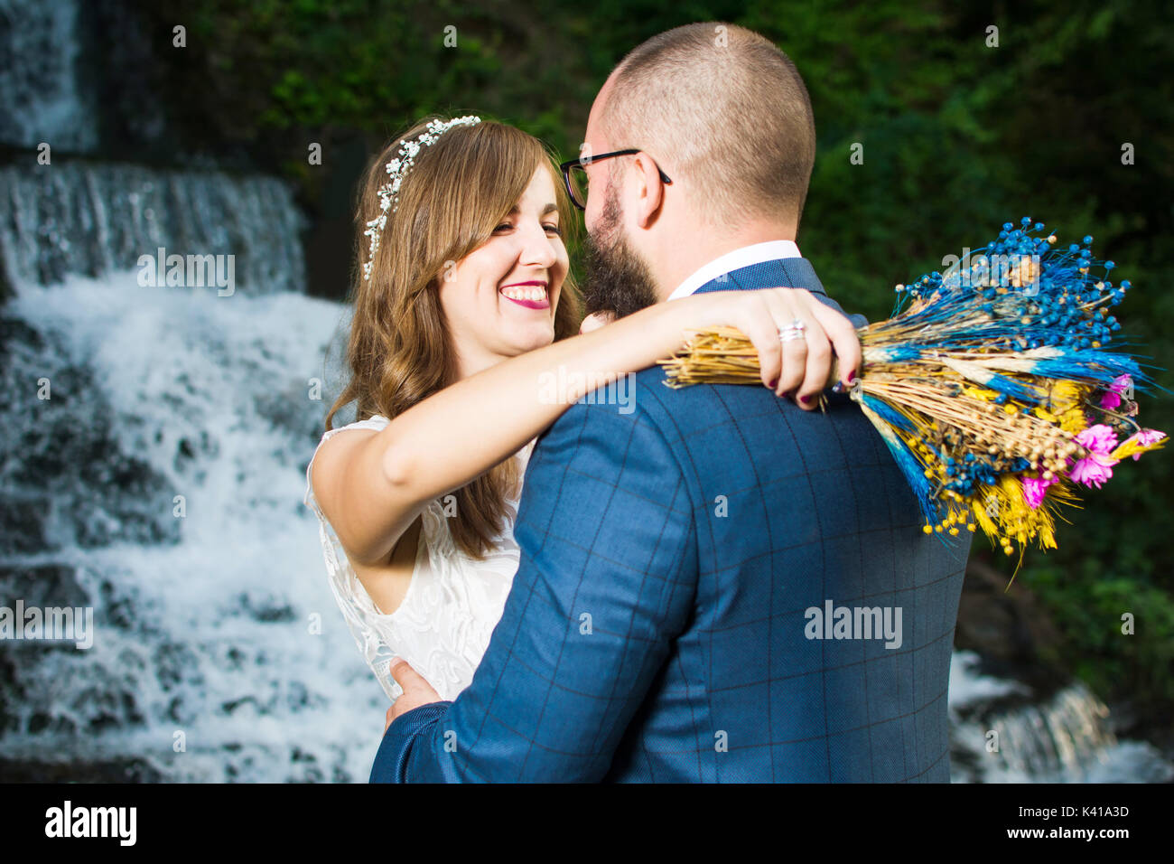 Hochzeit paar umarmen vor einem Wasserfall Stockfoto