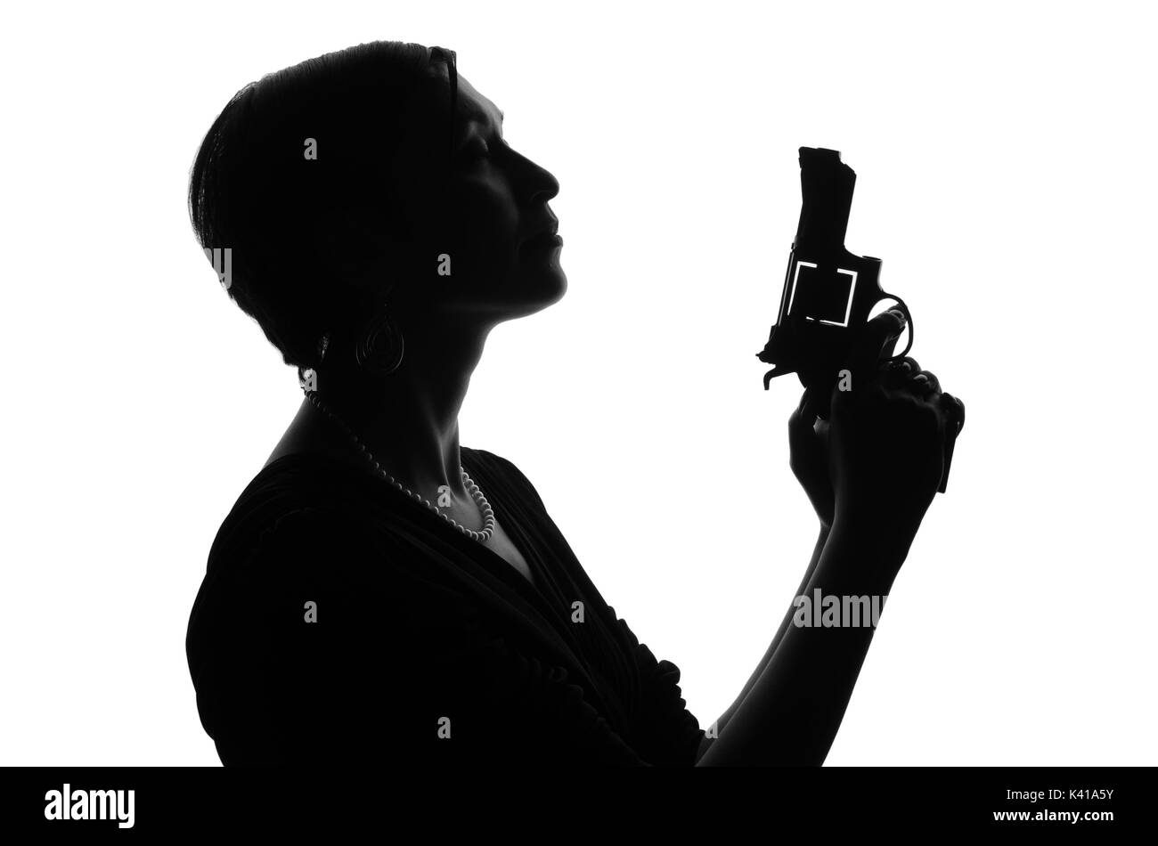 Silhouette einer Frau Privatdetektiv mit einer Waffe in der Hand. Gangster sieht aus wie Mafiosi und Aufenthalt Seite zur Kamera. Sie trägt ein Kleid. Polizei kriminelle Stockfoto