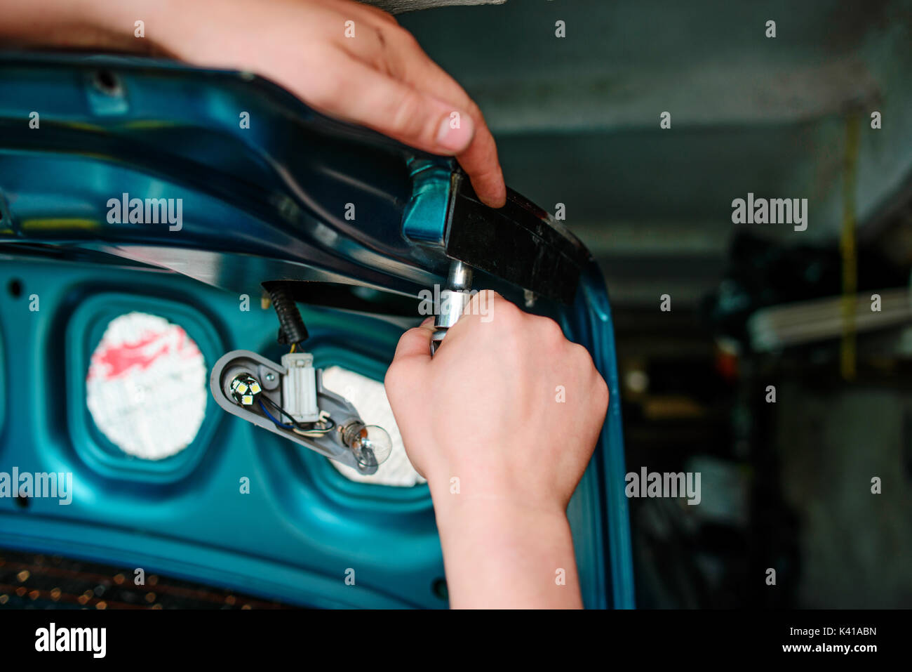 Closeup Instandsetzung eines defekten blaues Auto in der Garage durch die Hände von machanic. Stockfoto