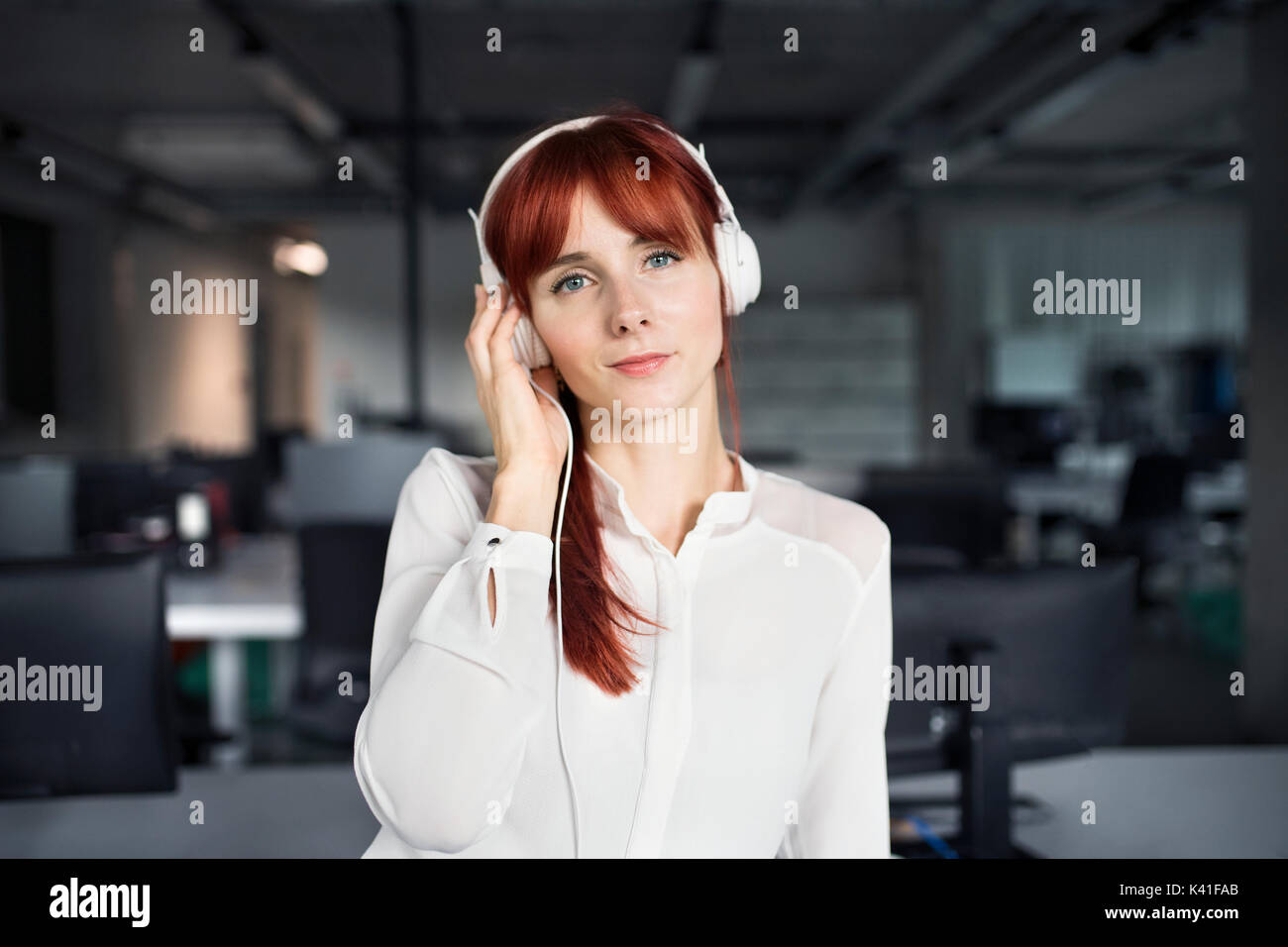 Geschäftsfrau mit großen Kopfhörern in Ihrem Büro. Stockfoto