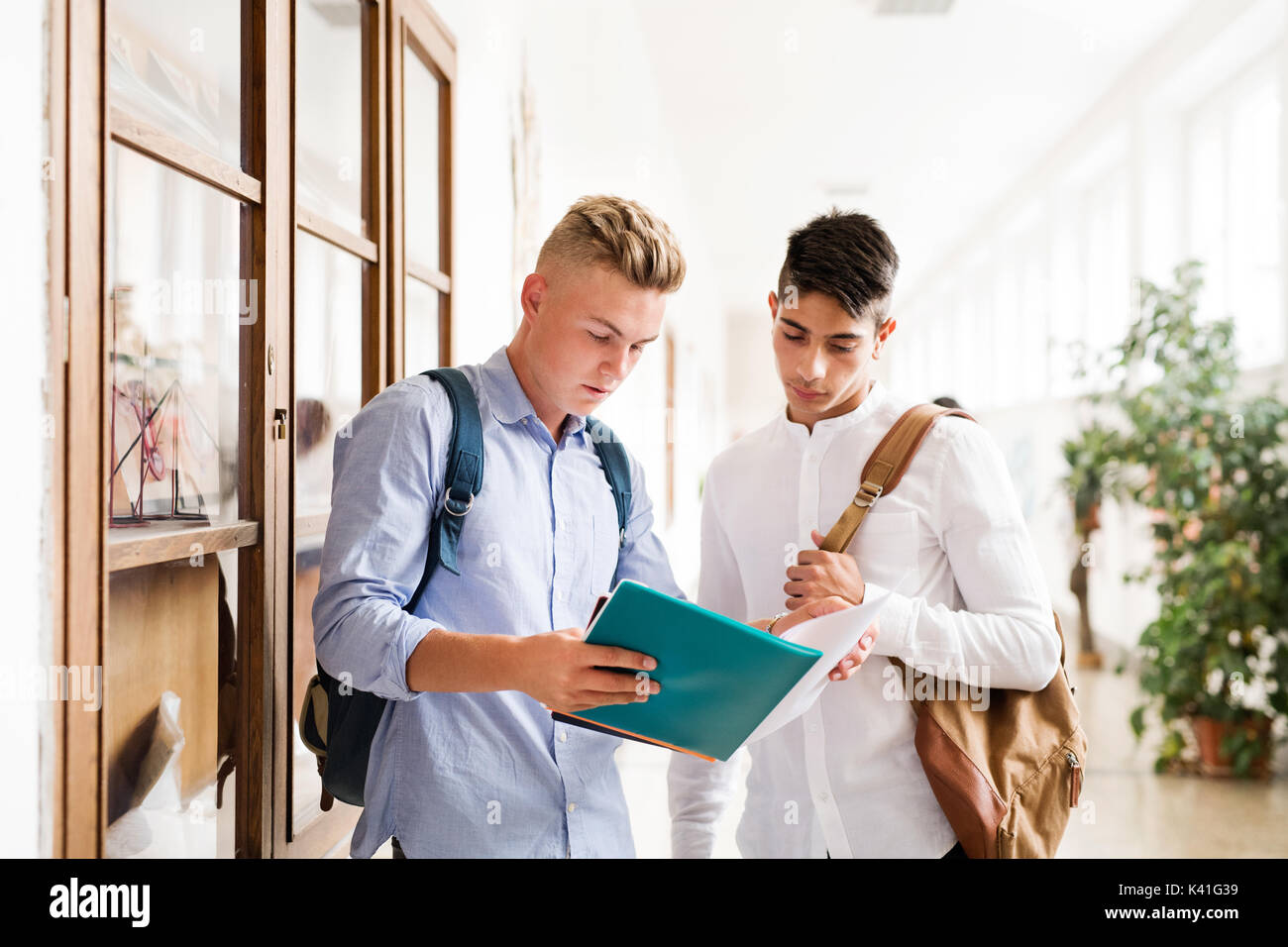 Jungs im Teenageralter mit Notebooks in der High School Halle während der Pause. Stockfoto