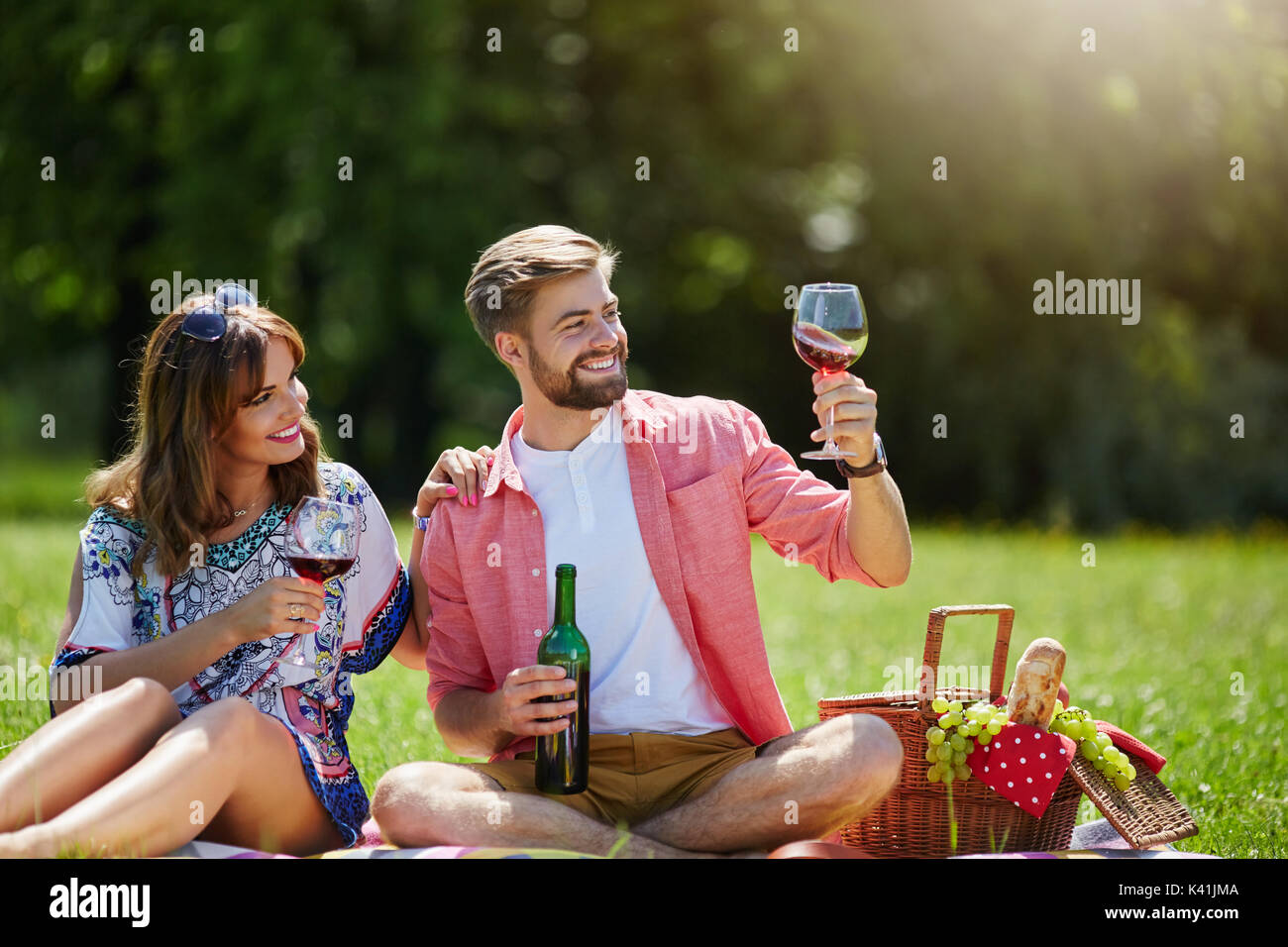 Ein Foto des jungen Paares auf Nachmittag Picknick entspannen. Sie versuchen einige Rotwein. Stockfoto