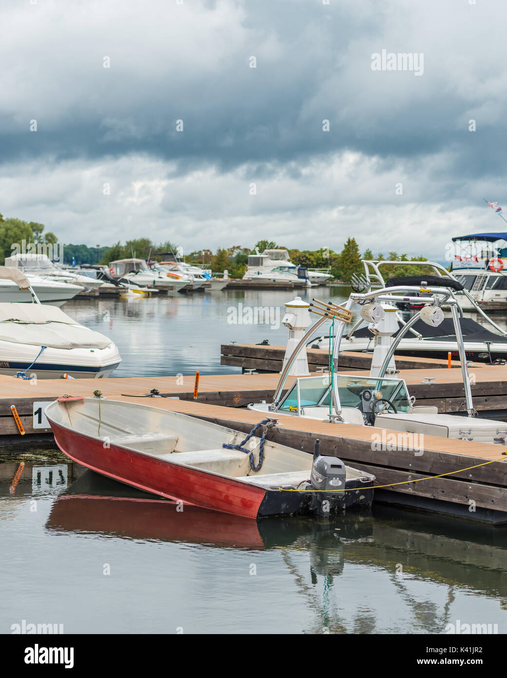 Kleine rote außenliegende Motorboot ist bei größeren teurer Yachten in Orillia Ontario zeigen, dass Bootfahren kann von allen genossen werden angedockt. Stockfoto