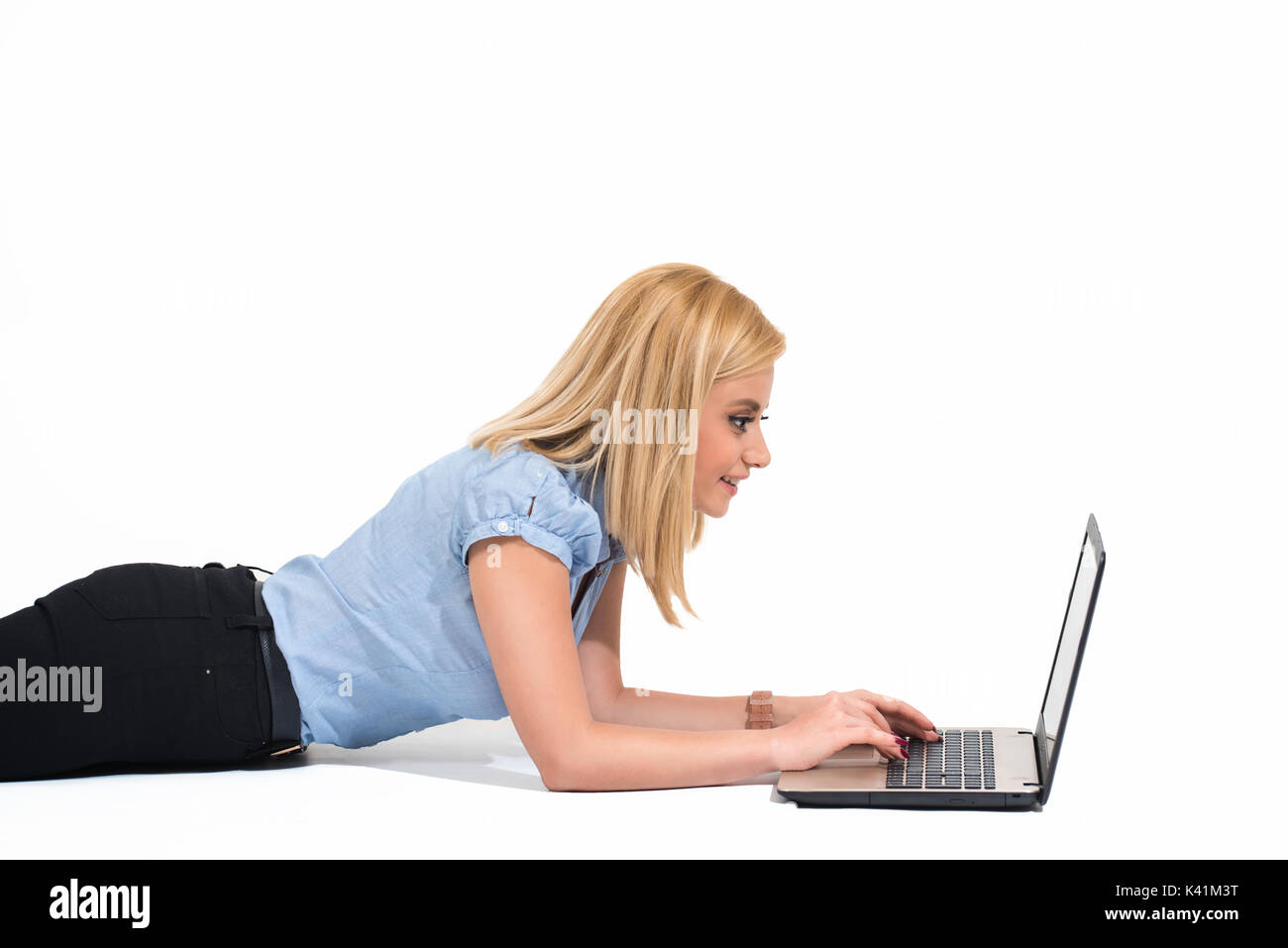 Junge blonde Frau, die Arbeit auf Laptop isoliert. Stockfoto