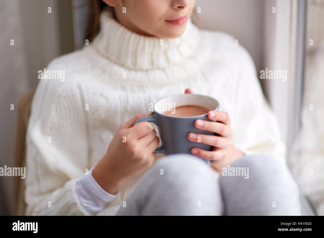 Mädchen mit Kakao Tasse suchen zu Hause Stockfoto