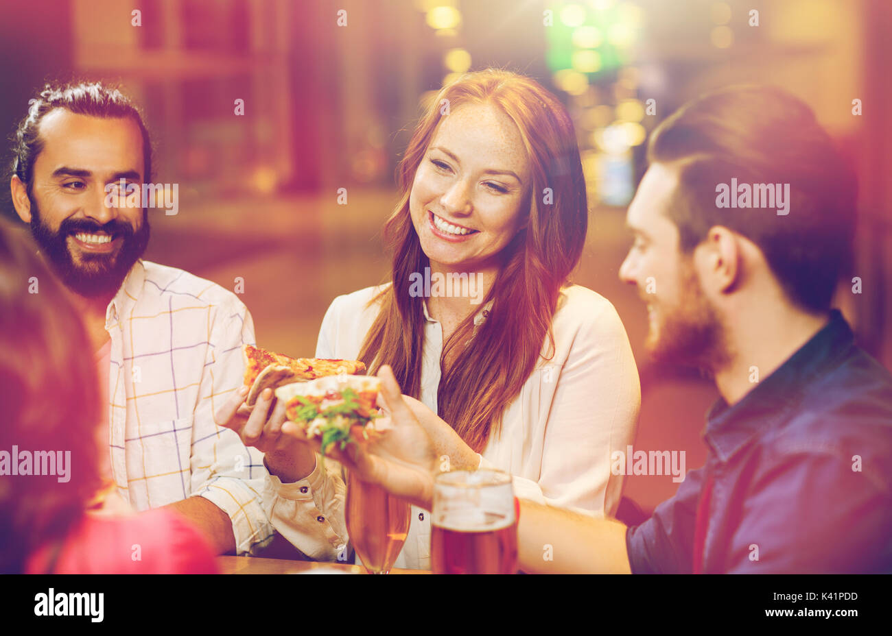 Freunde, die Pizza mit Bier im Restaurant Essen Stockfoto