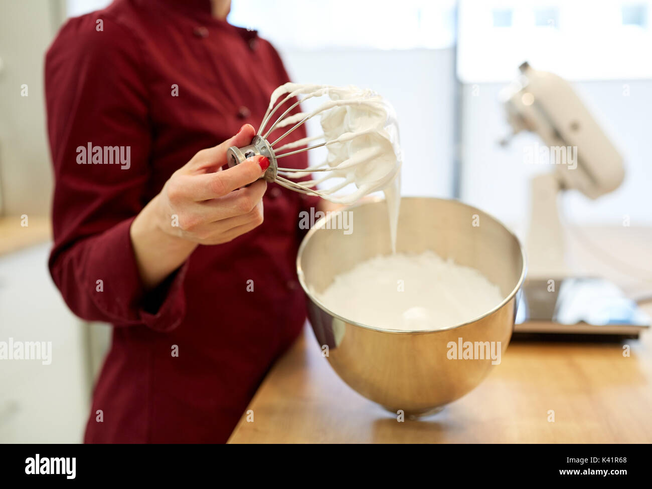 Koch mit Schneebesen und geschlagener Eischnee in Küche Stockfoto