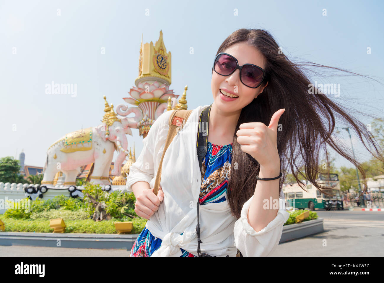 Lächelnd weibliche Reisende stand vor der berühmten Super Grand Palace Gebäude unter Bild und "Daumen hoch" Geste Gesicht Kamera auf Bangkok zu Stockfoto