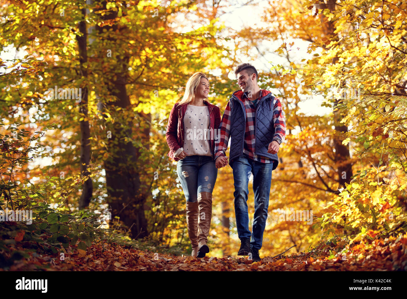 Lächelndes Paar in Liebe gehen im Park an einem sonnigen Herbsttag Stockfoto