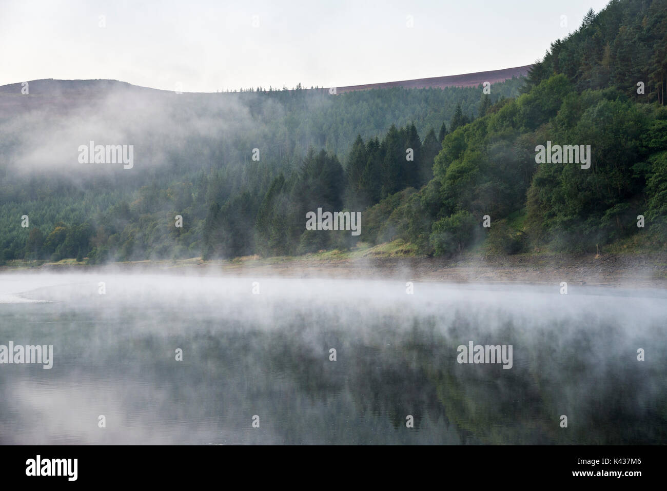 Atemberaubende September Morgen bei Ladybower Reservoir, Peak District, Derbyshire, England. Nebel über der Wasseroberfläche treiben. Stockfoto