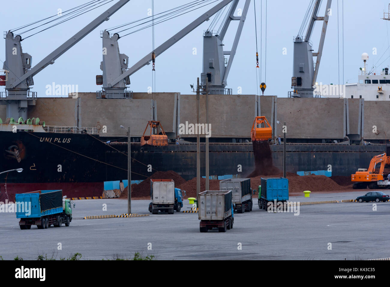 Uniplus bulk carrier Kränen entladen Lasten mit Kipper Warten auf Laden, Hualien Port, Hualien City, Taiwan Stockfoto