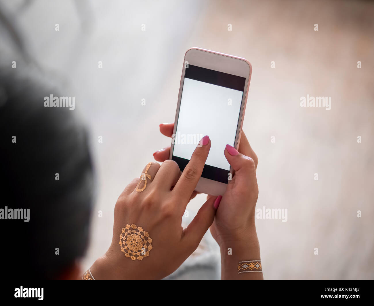 Frau mit zu Hause smartphone. Die Hände der jungen Mädchen mit Flash tattoo mithilfe von Mobile Device. Stockfoto