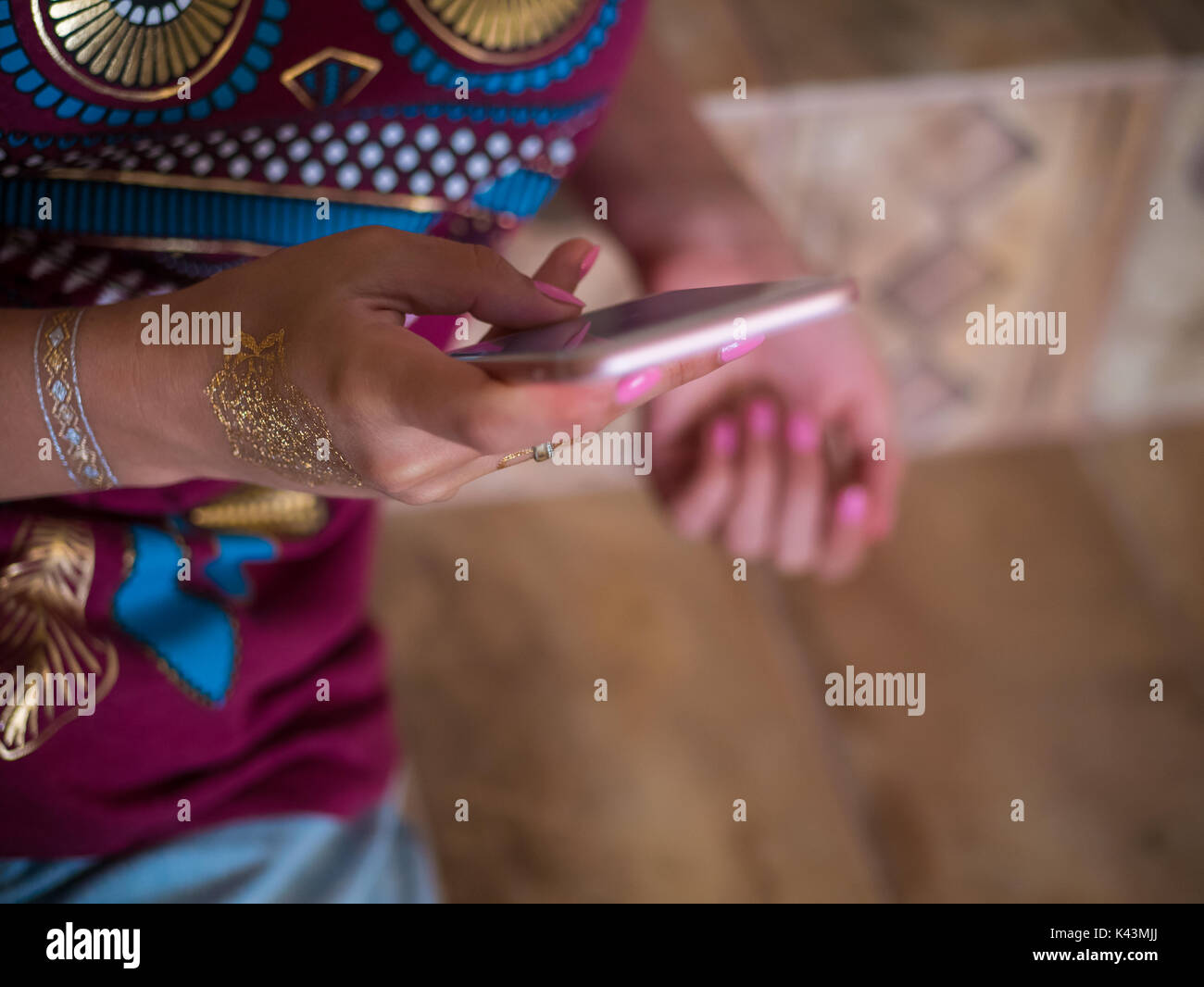Frau mit zu Hause smartphone. Die Hände der jungen Mädchen mit Flash tattoo mithilfe von Mobile Device. Stockfoto